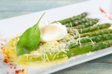 Tabak haşlanmış yumurta ve parmesan peyniri ile kuşkonmaz