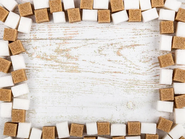 Flatlay of pieces of sugar on wooden background with copy space