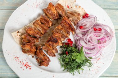 Tabak kızarmış et. Soğan, yeşillik ve nar Kebap
