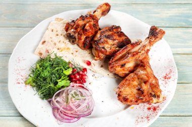 Plaka ile soğan, nar ve Yeşiller ahşap backgroundn üzerinde kızarmış tavuk