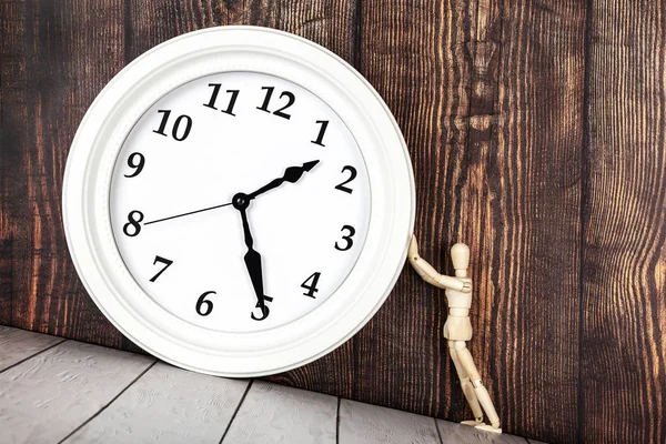 傾斜テーブルの上の時計を保持している木製の人物 時間や時間管理概念の制御 — ストック写真