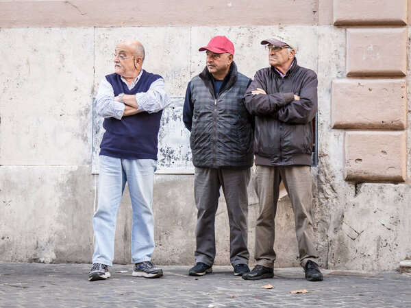 16 октября 2015 года. Рим, Италия: Трое старших итальянцев, стоящих на улице, выглядят серьезно
