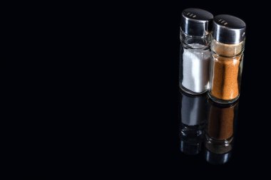 Biber ve tuz shakers yansıması ile siyah arka plan üzerine. Kopya alanı