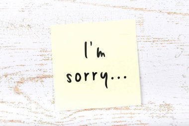 El yazısı metnini Im sorry ile ahşap masa üzerinde sarı yapışkan not