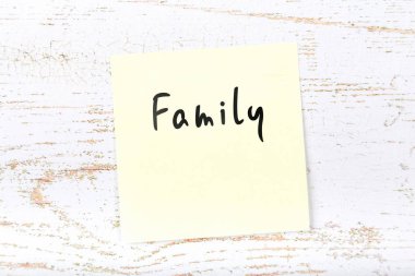 El yazısı metnini aile ile ahşap masa üzerinde sarı yapışkan not