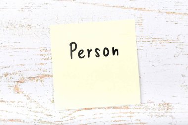 El yazısı metnini kişi ile ahşap masa üzerinde sarı yapışkan not