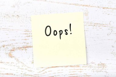 El yazısı metin ile ahşap masa üzerinde yapışkan not oops sarı