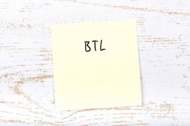 El yazısı terimi ile ahşap masa üzerinde sarı yapışkan not 