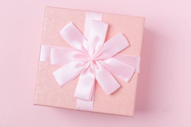 Pembe bir arka plan üzerinde yay ile dekoratif pembe hediye kutusu