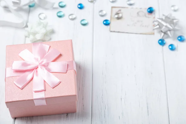 Flat lay of gift box and decorations on wooden table. Copy space