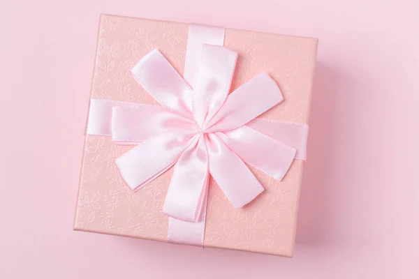 Decorative pink gift box with bow on pink background