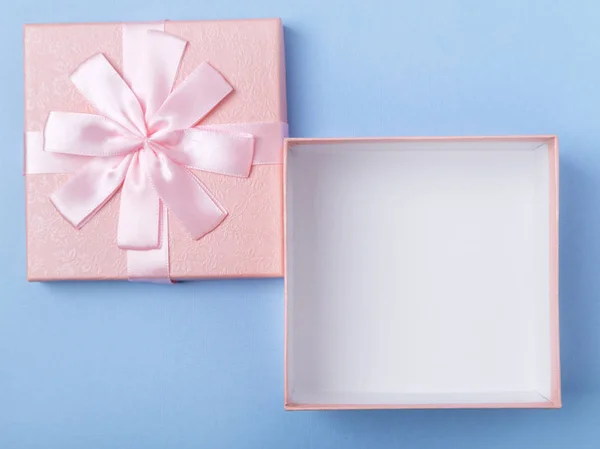 Arco de regalo rosa vacío sobre fondo de papel azul — Foto de Stock