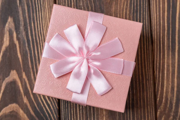 Caja de regalo rosa decorativa con lazo en mesa de madera marrón — Foto de Stock