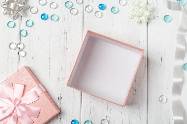 Caja de regalo rosa vacía y decoraciones en mesa de madera blanca — Foto de Stock
