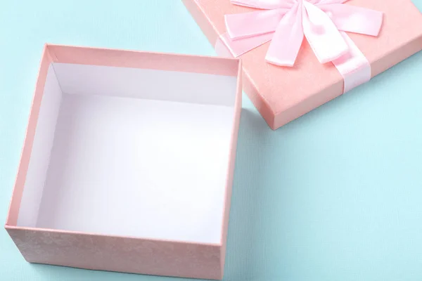 Caja de regalo rosa vacía y decoraciones en mesa de madera blanca sobre fondo de papel de color menta — Foto de Stock