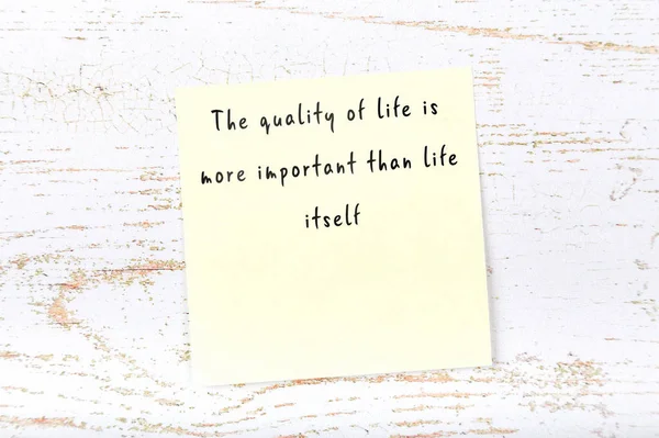 Positive inspiring quote handwritten on sticky note on wooden background