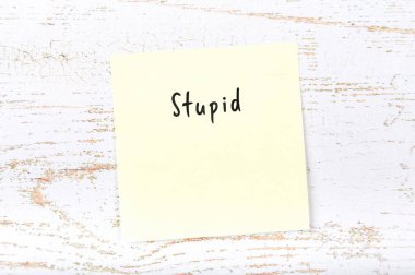 El yazısıyla yazılan kelime aptal ile sarı yapışkan not