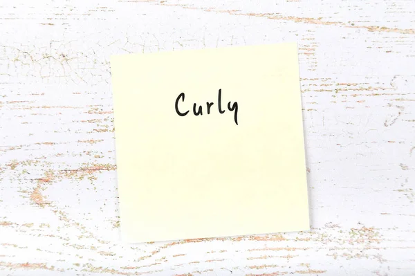 Gele kleverige nota met handgeschreven woord krullend — Stockfoto