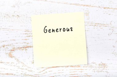 El yazısıyla yazılan kelime cömert ile sarı yapışkan not