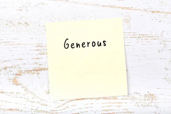 Yellow sticky note with handwritten word generous — Stock Photo, Image