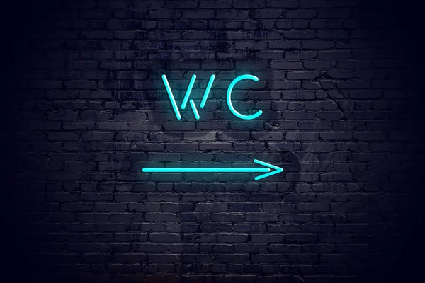 Brick wall with neon arrow and sign wc