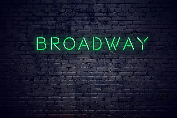 Brick wall at night with neon sign broadway