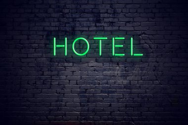 Neon işareti otel ile gece tuğla duvar