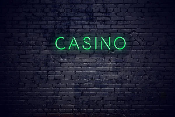 Brick wall at night with neon sign casino