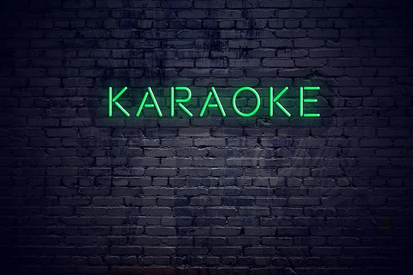 Cihlová zeď v noci s neon sign karaoke — Stock fotografie