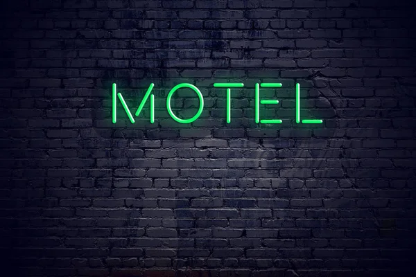 Brick wall at night with neon sign motel