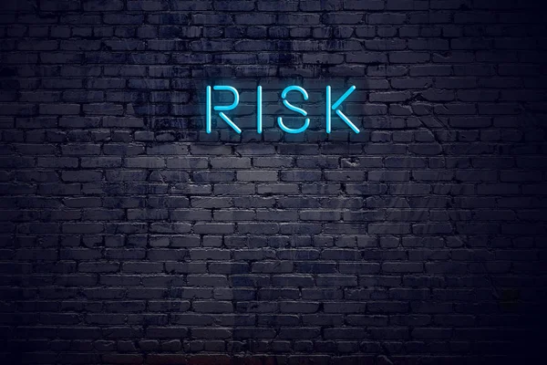 Brick wall and neon sign with text risk — Stock Photo, Image