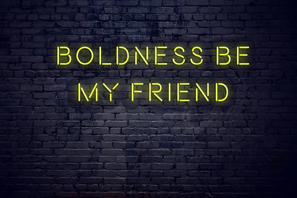 Positive inspiring quote on neon sign against brick wall boldness be my friend