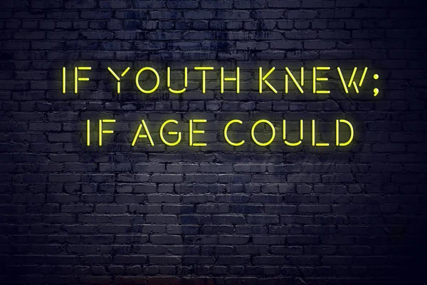 Positive inspiring quote on neon sign against brick wall if youth knew if age could