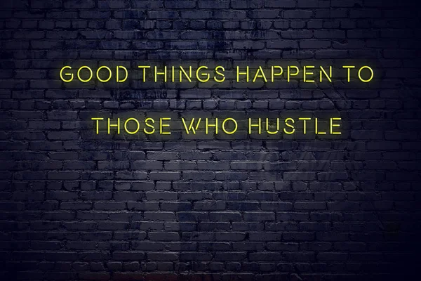 Positive inspiring quote on neon sign against brick wall good things happen to those who hustle — Stock Photo, Image