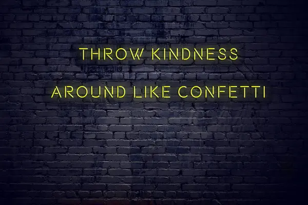 Positive inspiring quote on neon sign against brick wall throw kindness around like confetti — Stock Photo, Image