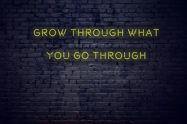 Positief inspirerend citaat op lichtreclame tegen muur groeien door wat u doorlopen — Stockfoto