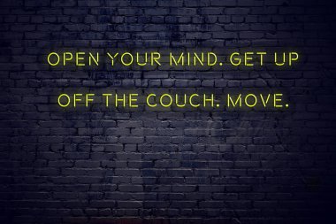 Positive inspiring quote on neon sign against brick wall open your mind get up off the couch move clipart