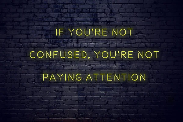 Positive inspiring quote on neon sign against brick wall if youre not confused youre not paying attention — Stock Photo, Image