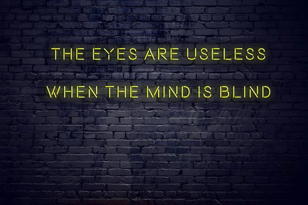 Positive inspiring quote on neon sign against brick wall the eyes are useless when the mind is blind