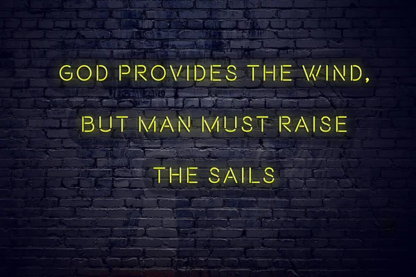 Positive inspiring quote on neon sign against brick wall god provides the wind but man must raise the sails — Stock Photo, Image