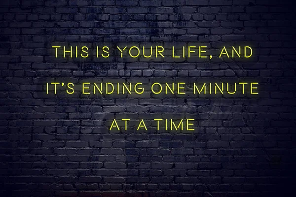 Позитивная вдохновляющая цитата на неоновом знаке против кирпичной стены это ваша жизнь и ее конец одну минуту за раз — стоковое фото