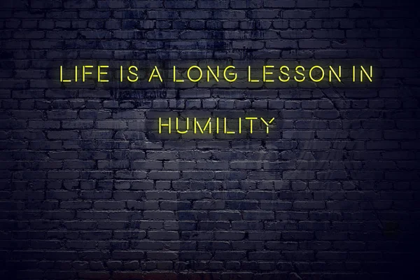 Positive inspiring quote on neon sign against brick wall life is a long lesson in humility — Stock Photo, Image