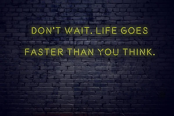 Positivt inspirerande citat på neonskylt mot tegel vägg inte vänta livet går snabbare än du tror — Stockfoto