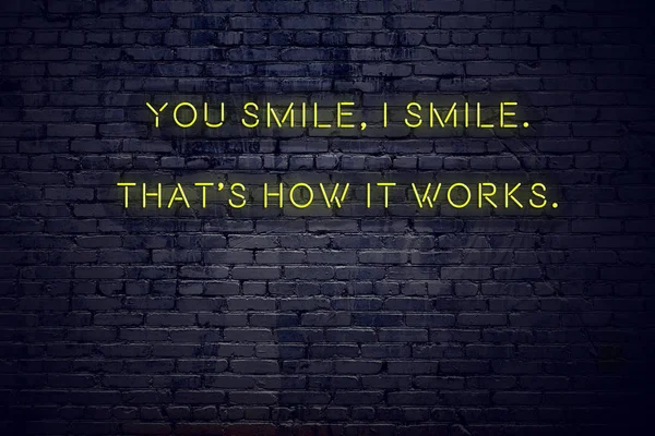 Positive inspiring quote on neon sign against brick wall you smile thats how it works — стоковое фото