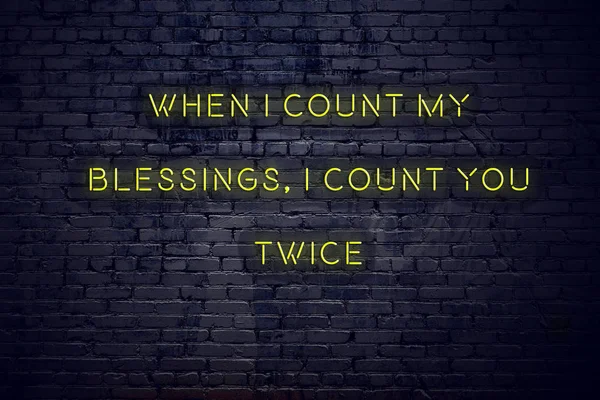 Positive inspiring quote on neon sign against brick wall when i count my blessings i count you twice