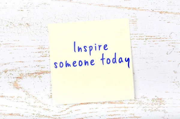Yellow sticky note with handwritten text inspire someone today — Stock Photo, Image
