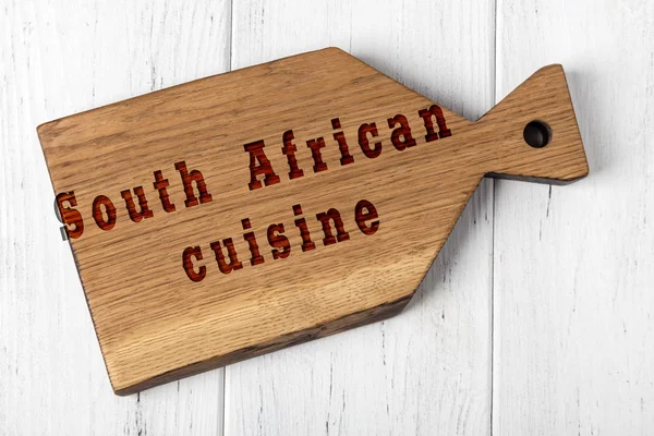 Wooden cutting board with inscription. Concept of south african cuisine — Stock Photo, Image