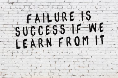 Boyalı siyah motivasyonel alıntı yazıtı ile beyaz tuğla duvar