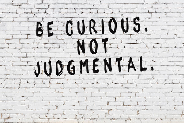 White brick wall with painted black motivational quote inscription