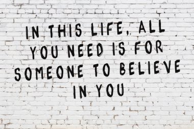 Boyalı siyah motivasyonel alıntı yazıtı ile beyaz tuğla duvar